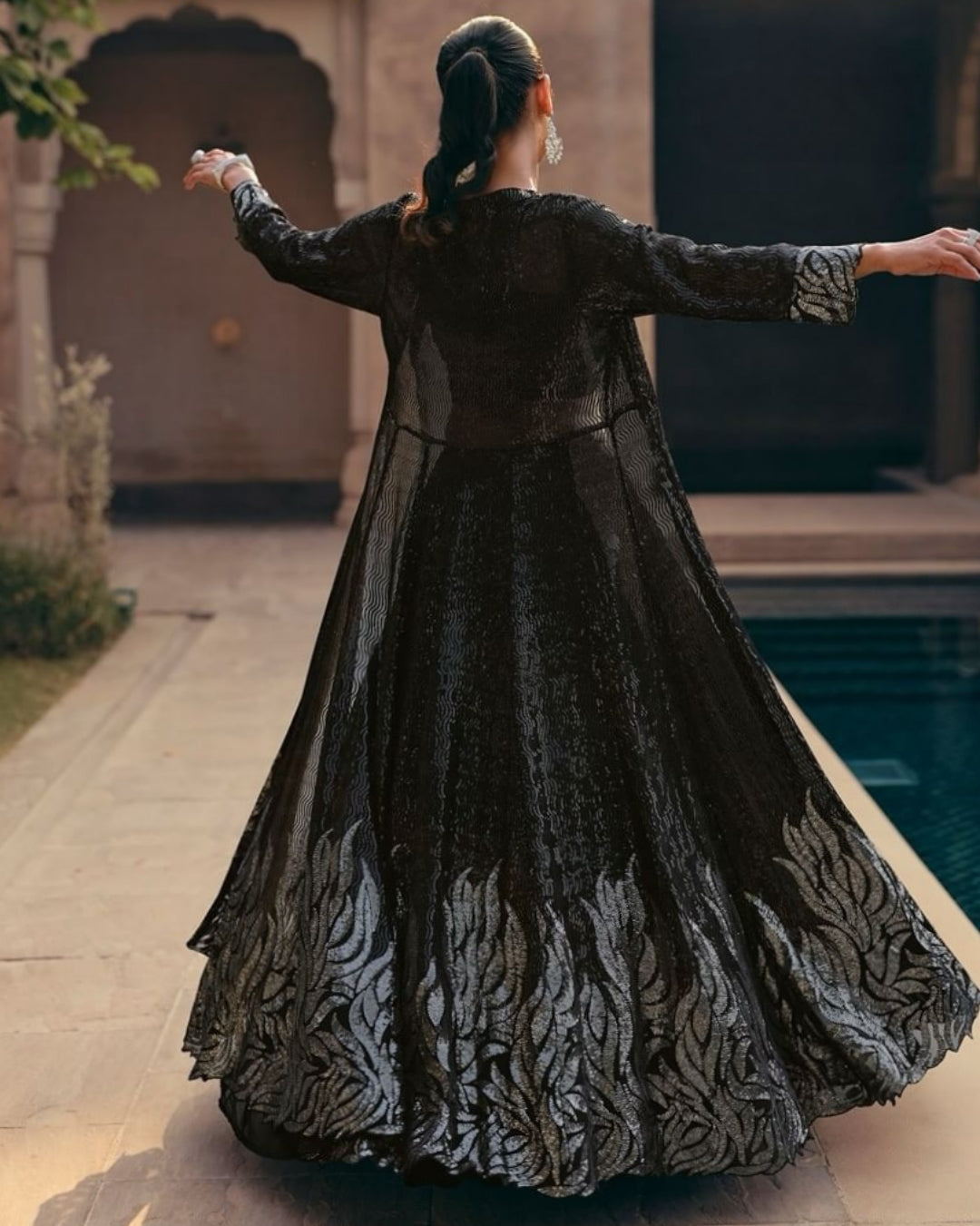 Back view of the chic black sequin lehenga set, featuring the design and detailing on the back of the crop top and dupatta.